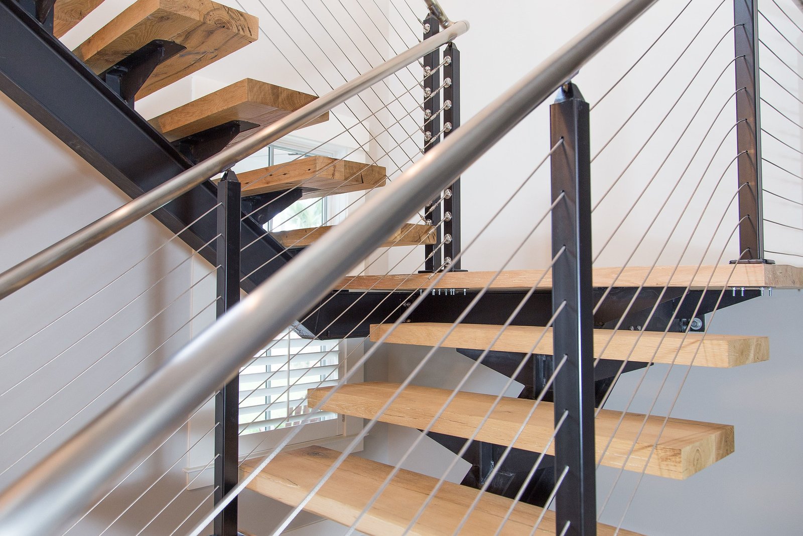 Floating stair treads and cable railing seen in detail