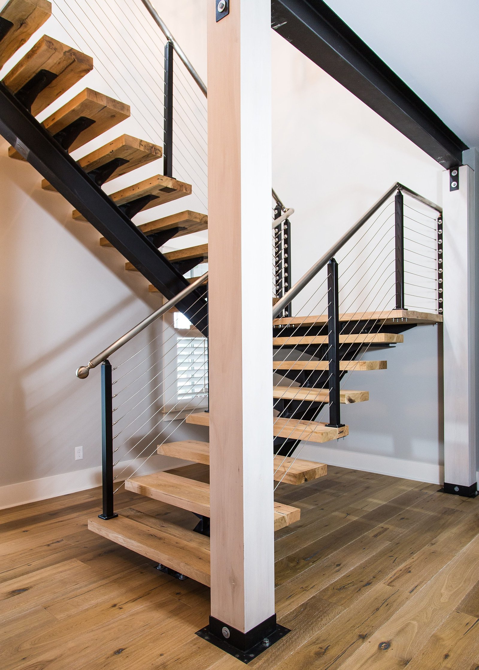 Floating wood staircase with a stainless cable railing