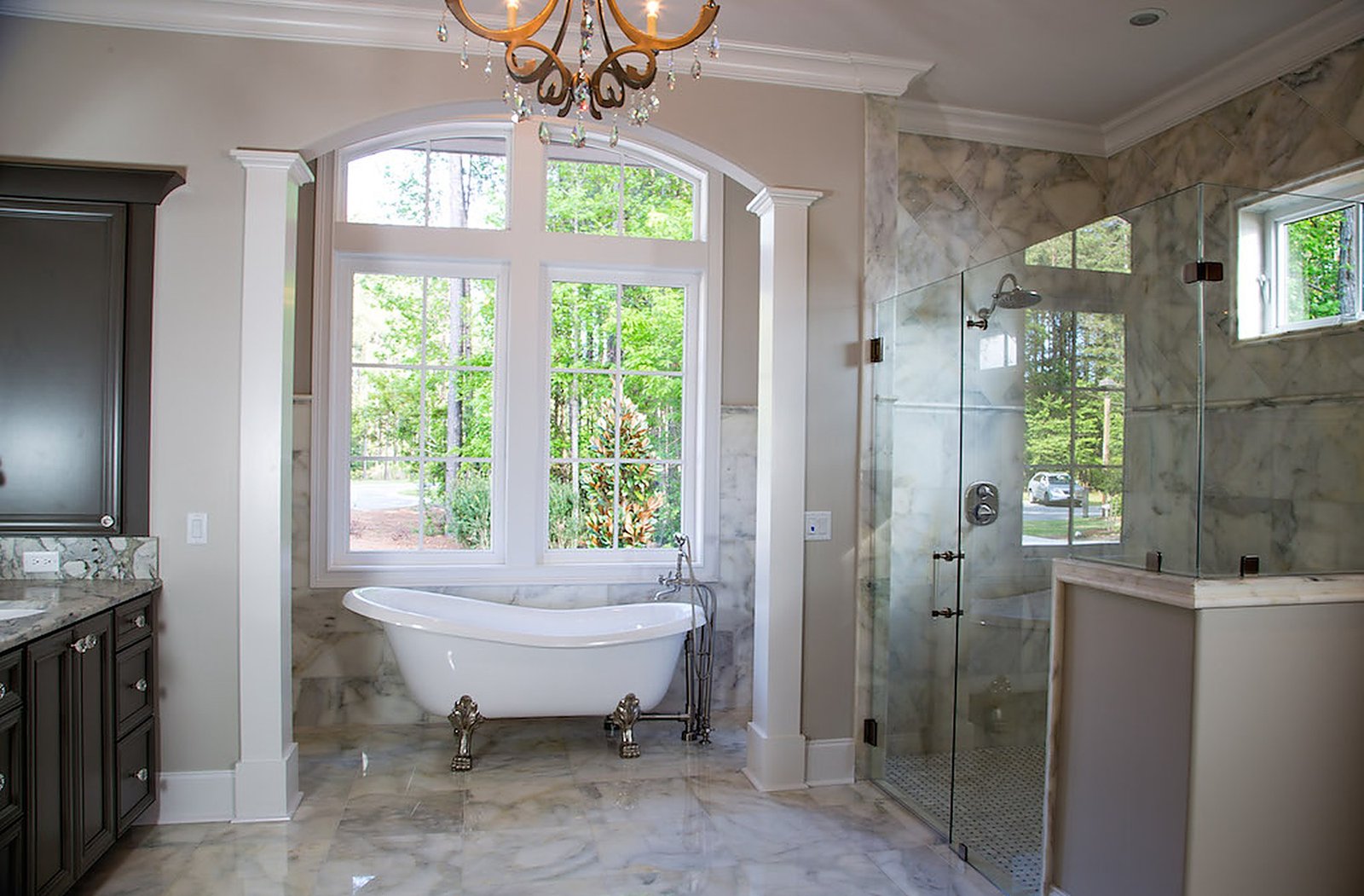 Master bath with a freestanding soaking tub and a glass shower in natural light